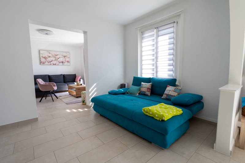 living room with a sofa bed, a couch, a coffee table, a rug, a picture, and a chair