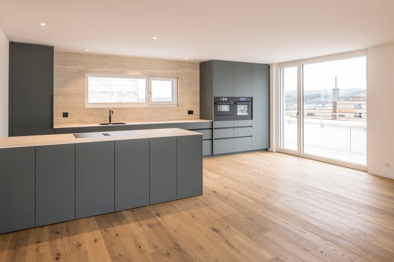 modern kitchen with wooden floor, gray cabinets, large window, double oven, sink, faucet, island