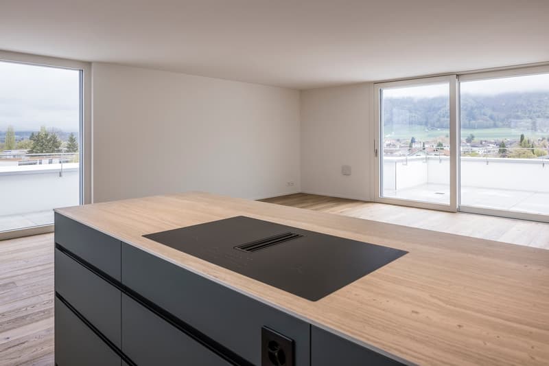 modern kitchen with wooden countertops, black induction hob, large windows, balcony