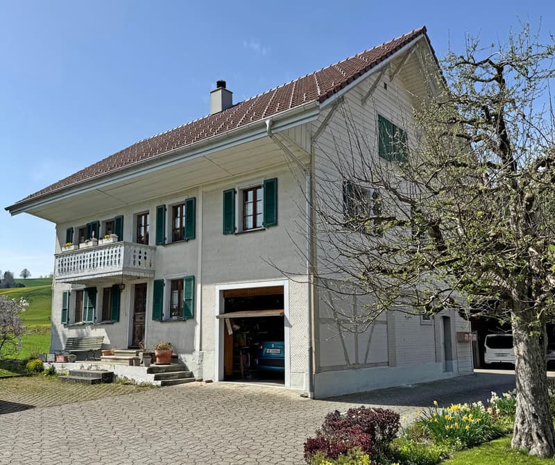 2 story house, white exterior, brown roof, balcony, garage, garden, green shutters, chimney, bench, potted plants