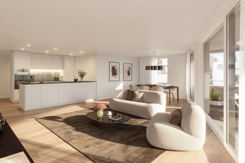 Open-concept living room and kitchen with white walls, hardwood floors, large windows, white sofa, coffee table, and dining table with chairs. The kitchen features white cabinets and countertops.