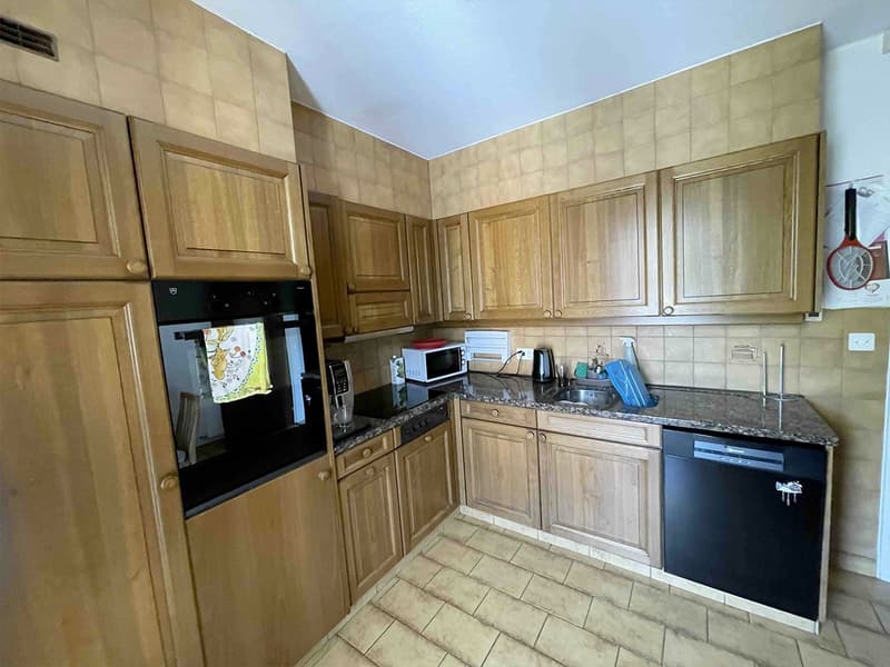 Wooden cabinets, granite countertop, dishwasher, washing machine, microwave, sink, power outlet, faucet, toaster, knife hanging on wall