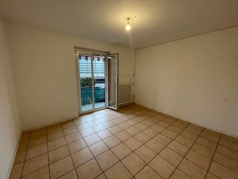 empty room, tiled floor, sliding glass door to balcony, heater