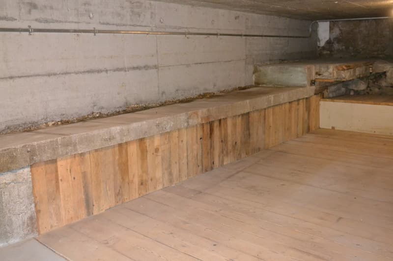 Concrete walls, wooden paneling, wooden floor, storage space