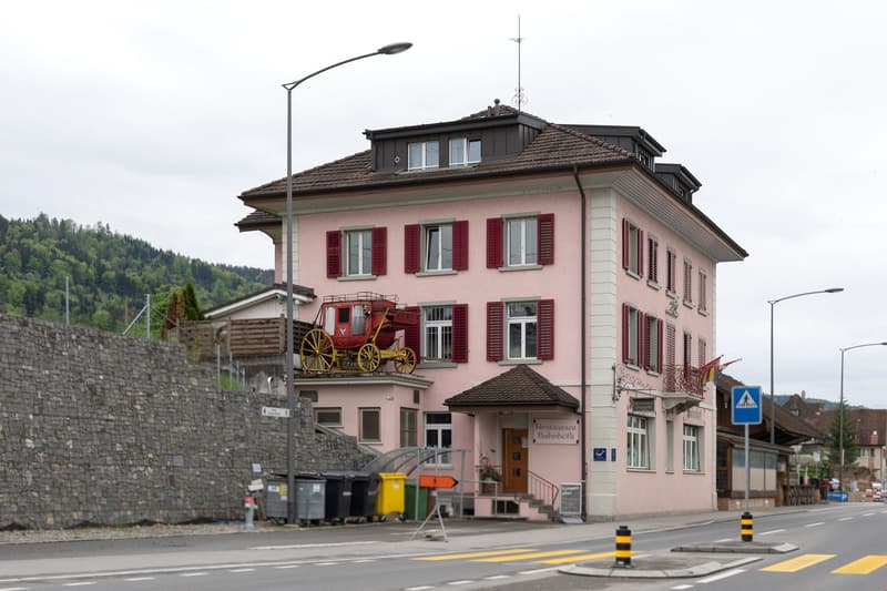 pink house, red shutters, vintage carriage, stone wall, mountains in the background