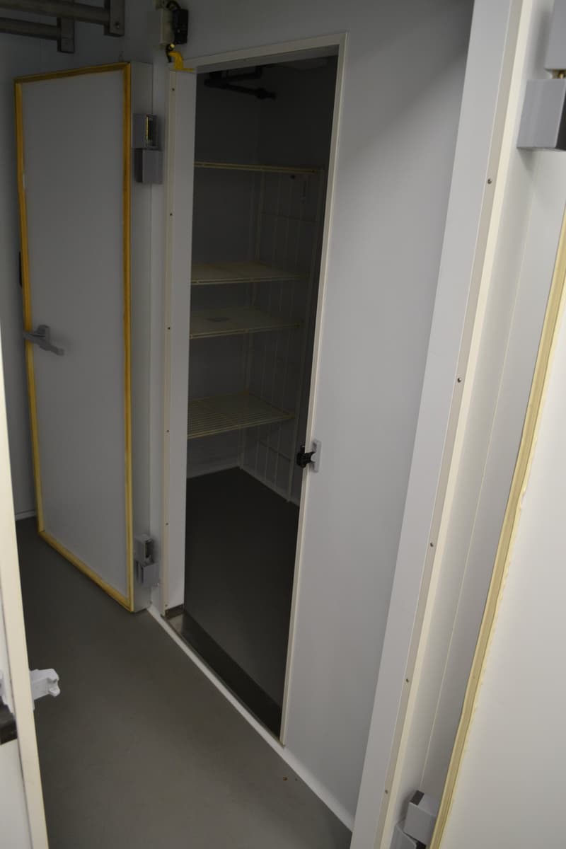 white cabinet door, silver handles, empty room, wooden shelving, gray flooring