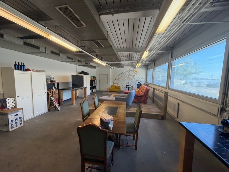 large room, dining table, chairs, cabinets, shelves, windows, map on wall, couches, television