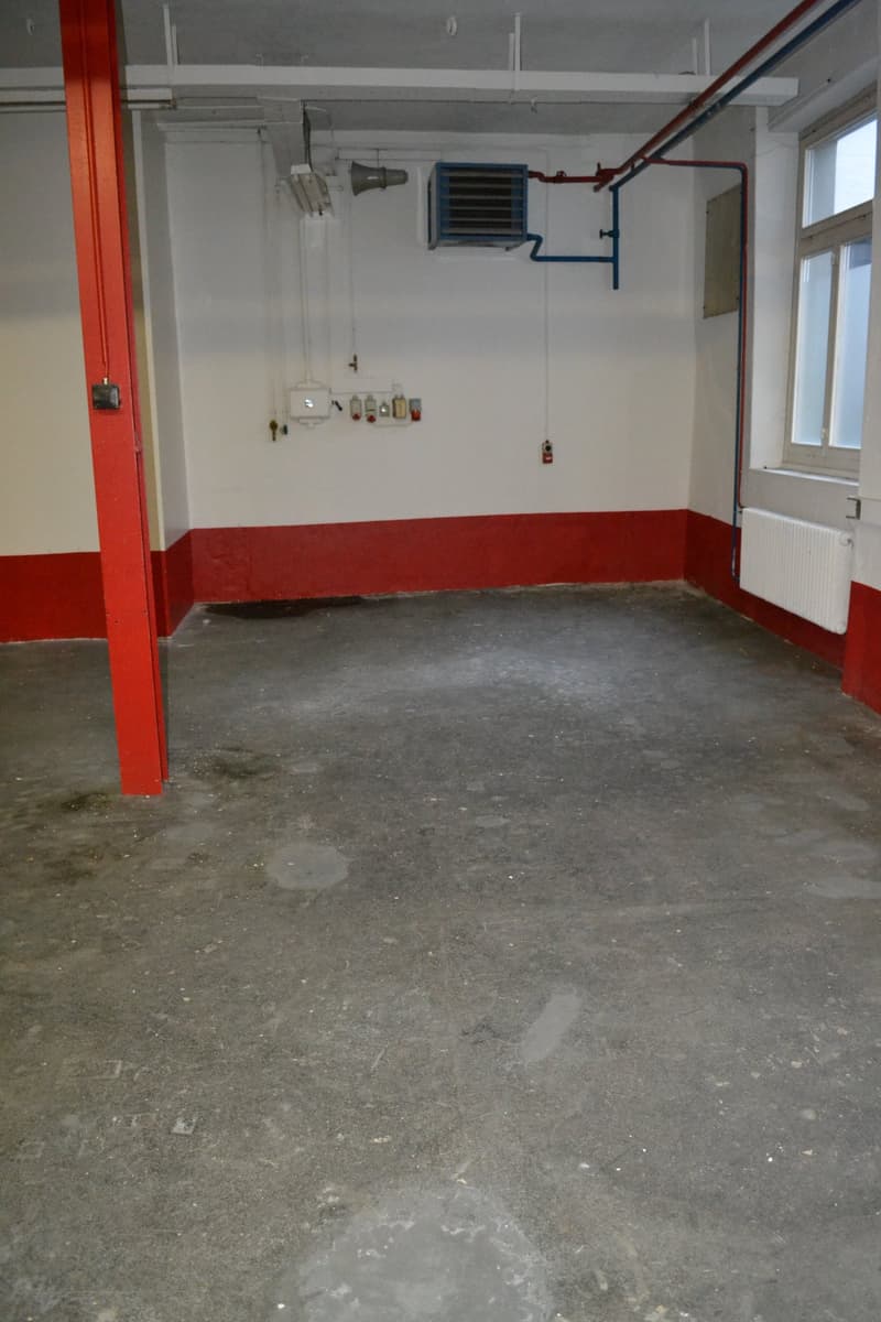 Empty room with concrete floor, red and white walls, a window, and a radiator