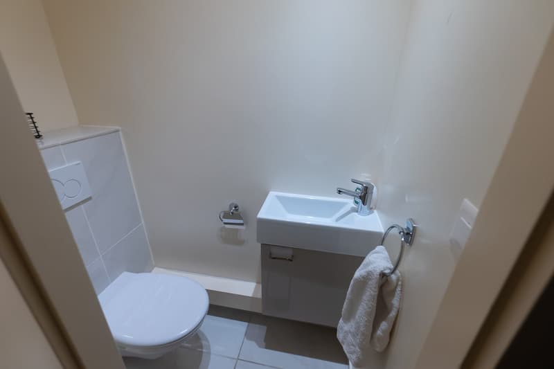 small bathroom with toilet, sink, and towel rack