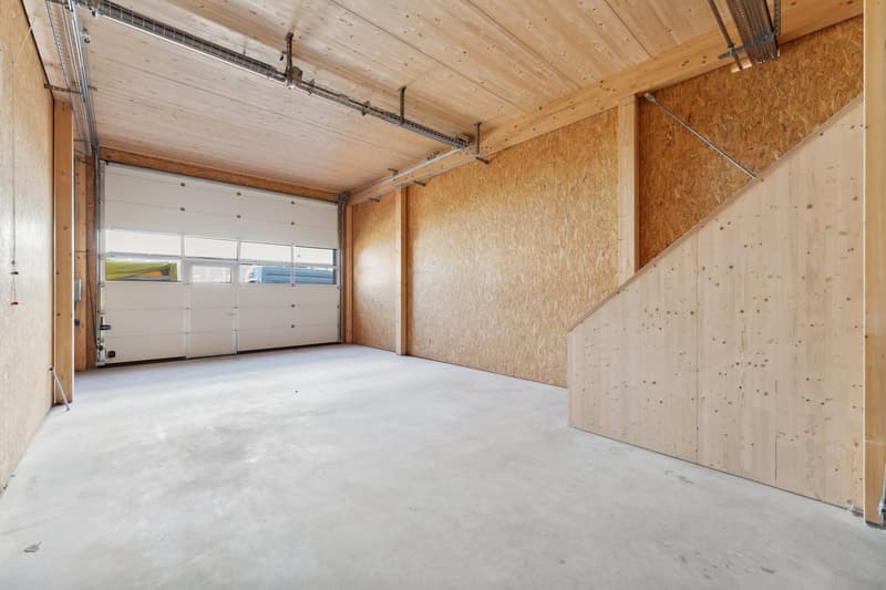 garage with wooden walls, wide door, white floor