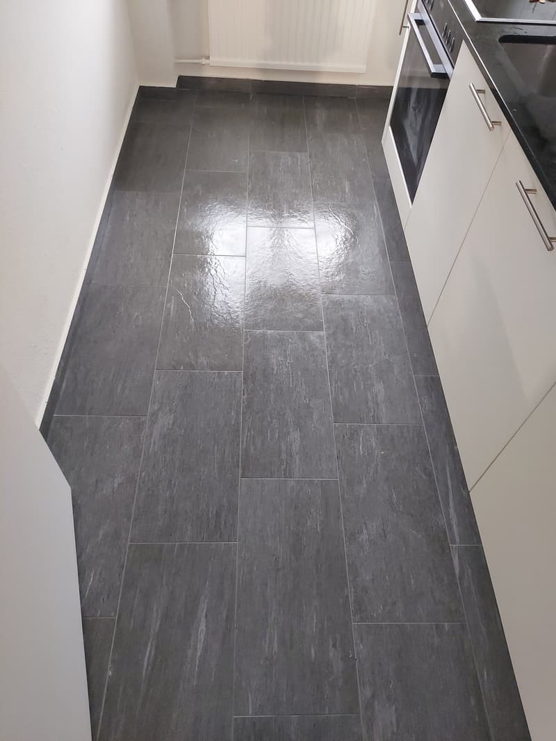 modern white cabinetry, black tiled floor, kitchen appliance