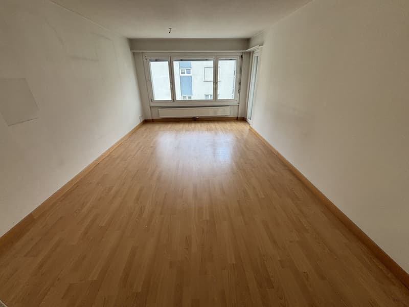 empty room, wooden floor, white walls, large window, radiator