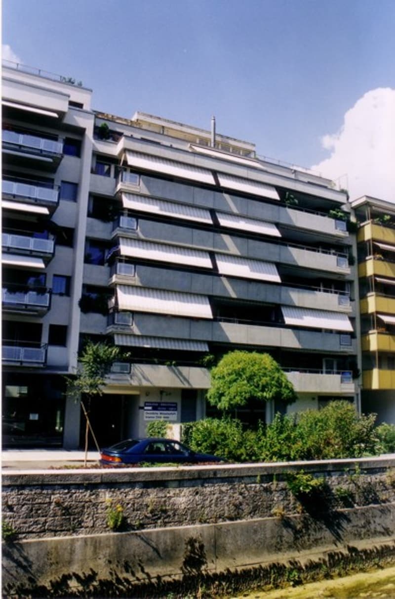 multi-story building, balconies, windows, car parked in front