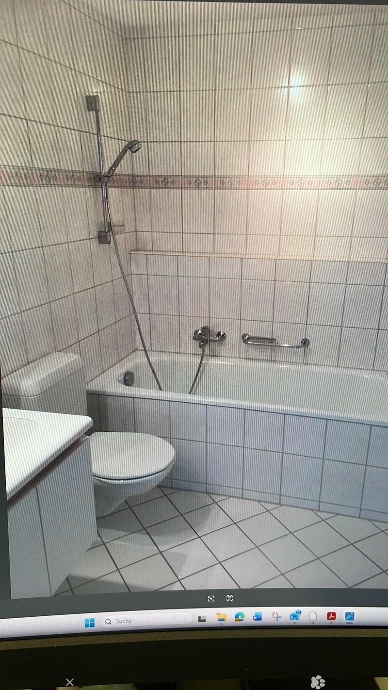 Bathroom with bathtub, toilet, sink, shower head, tiled walls, white tiles