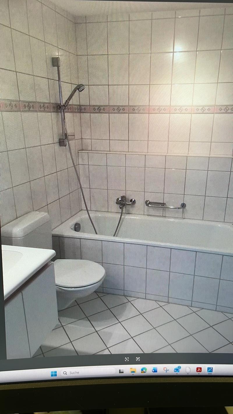 Bathroom with bathtub, toilet, sink, shower head, tiled walls, white tiles