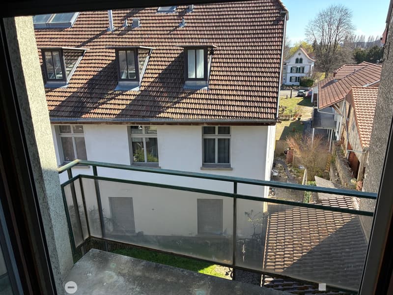 2 story house, brown roof, white walls, glass balcony railing, glass windows, garden