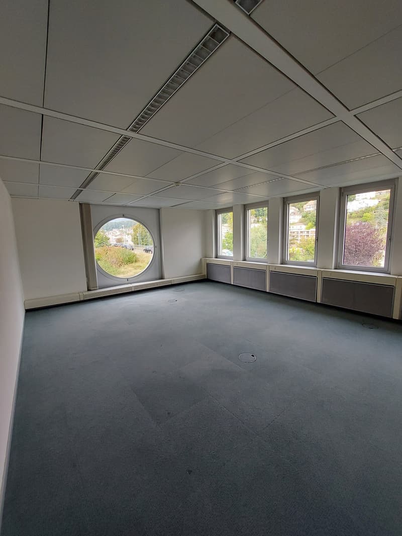 empty room, grey carpeting, white walls, large window, circular window