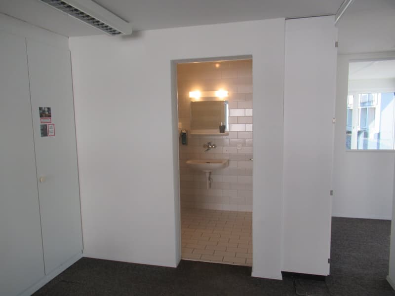 bathroom with white tiles, a sink, mirror, and shower