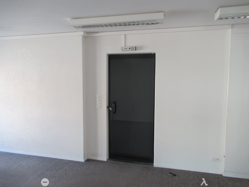 empty room with a door, white walls, gray floor, closed door