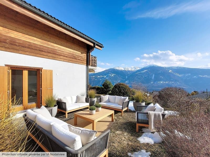 Outdoor seating area with wooden furniture, white cushions, wooden coffee table, potted plants, wooden house, snowy mountains in the background