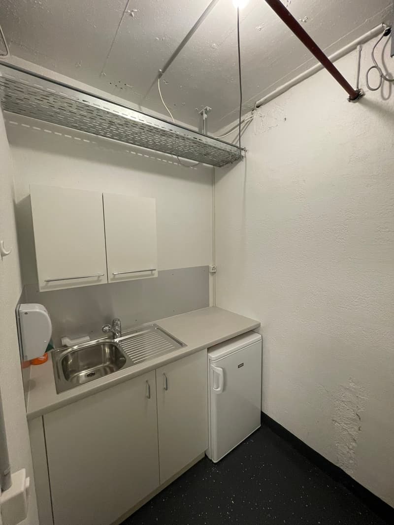 small kitchen area with sink, faucet, and refrigerator