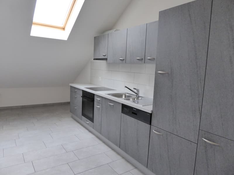 empty kitchen with light tile flooring, grey cabinets, stainless steel sink, dishwasher