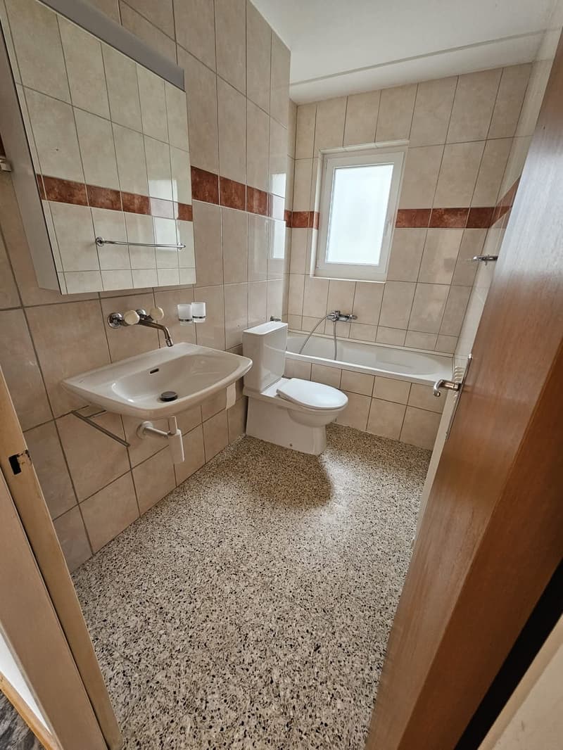 Modern bathroom with white toilet, sink, and bathtub