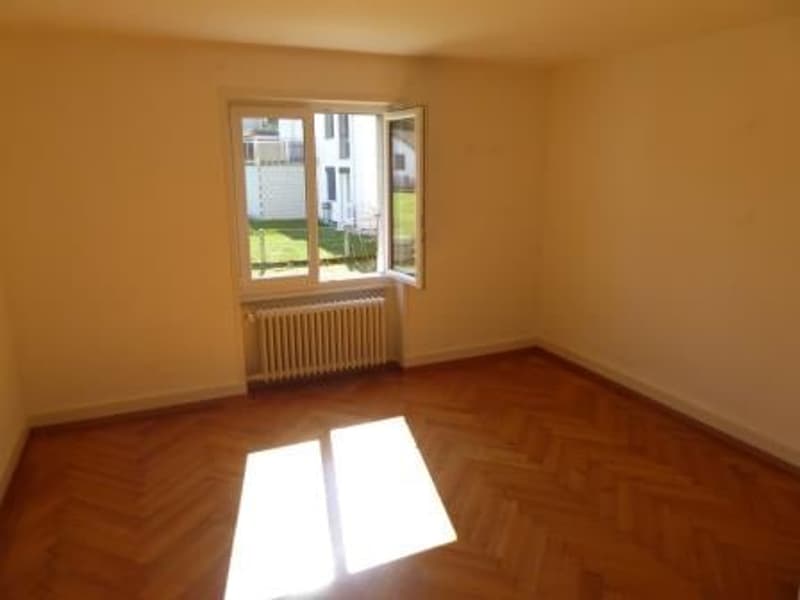 Empty room with wooden parquet floor, radiator, French window