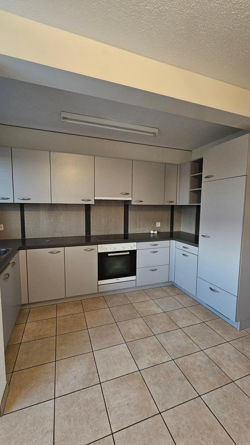 white cabinets, black countertops, built-in oven, sink, tile flooring, power outlet