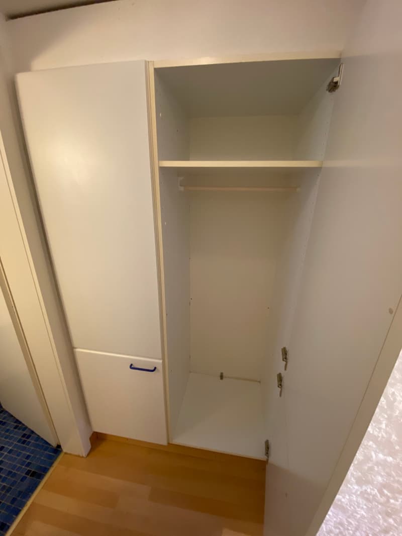 Empty white wardrobe with a drawer and hanging space