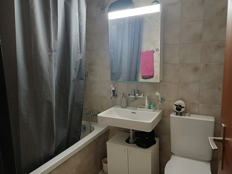 Bathroom with bathtub, sink, mirror, and toilet.