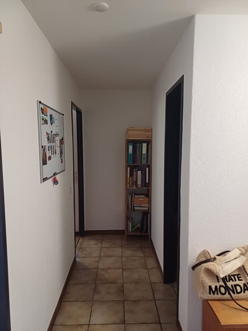 tiled floor, white walls, bulletin board, bookshelf, handbag