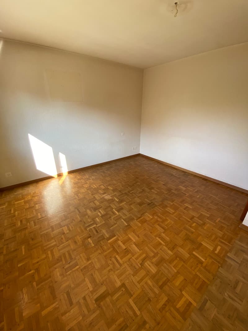 empty room, wooden parquet floor, white walls, power outlets on the wall