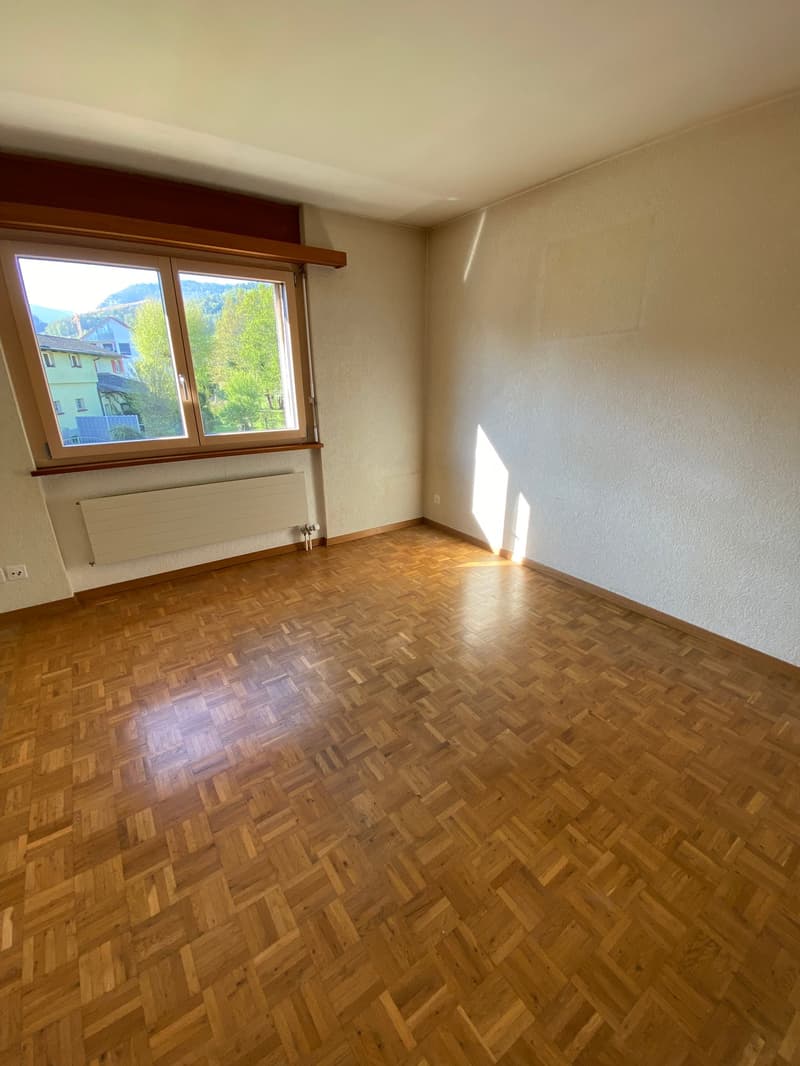 empty room, wooden parquet floor, large window, white walls, radiator