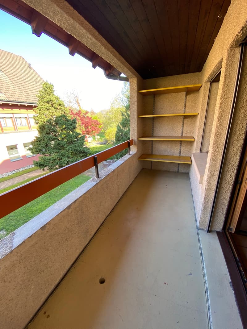 empty balcony with wooden railing, yellow shelves, concrete floor