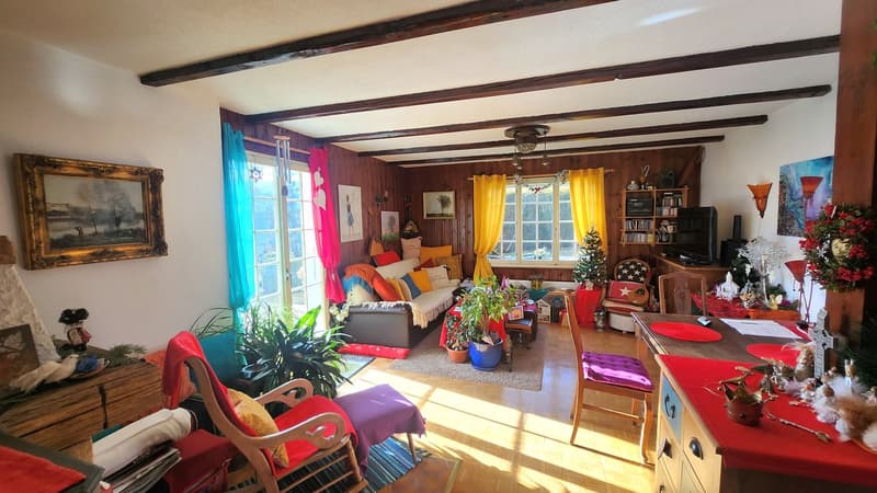 wooden walls, large windows, couch, armchairs, coffee table, TV, Christmas decorations