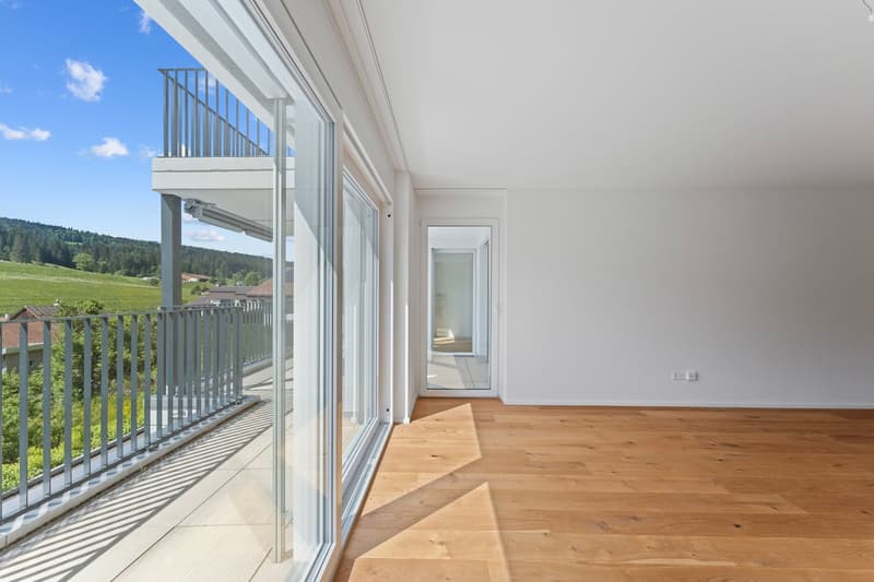 large windows, balcony with metal railing, hardwood floors, white walls