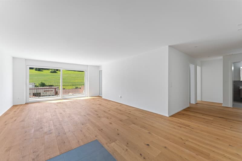 empty room, white walls, glass doors leading to balcony, wooden floor