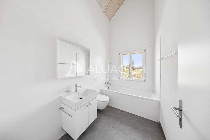 Lichtdurchflutetes Badezimmer mit Badewanne und modernem Flair