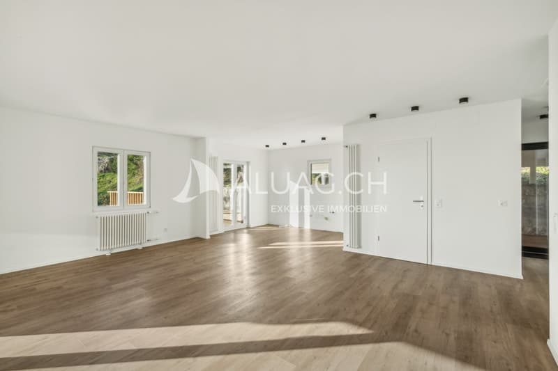 Offener Wohnbereich mit Holzboden und Zugang zur Terrasse für gesellige Stunden