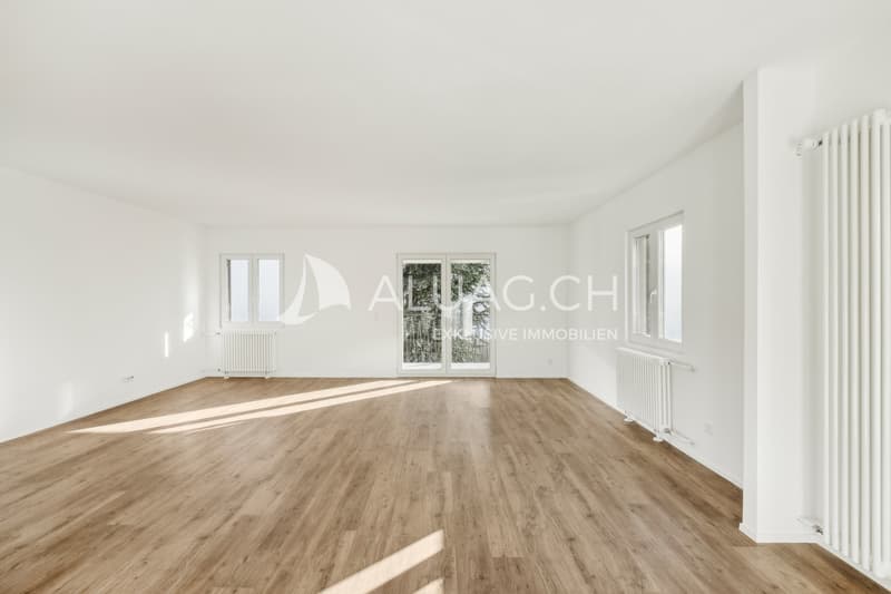 Weitläufiger Wohnraum mit viel Tageslicht und einer einladenden, modernen Gestaltung.