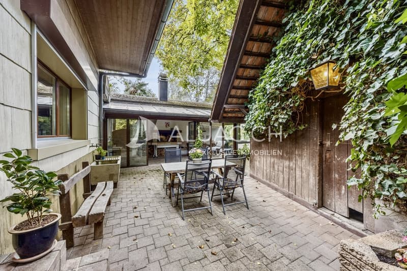Gemütlicher Innenhof mit Blick in den Wintergarten, der mit Kamin und viel Charme zum Verweilen einlädt