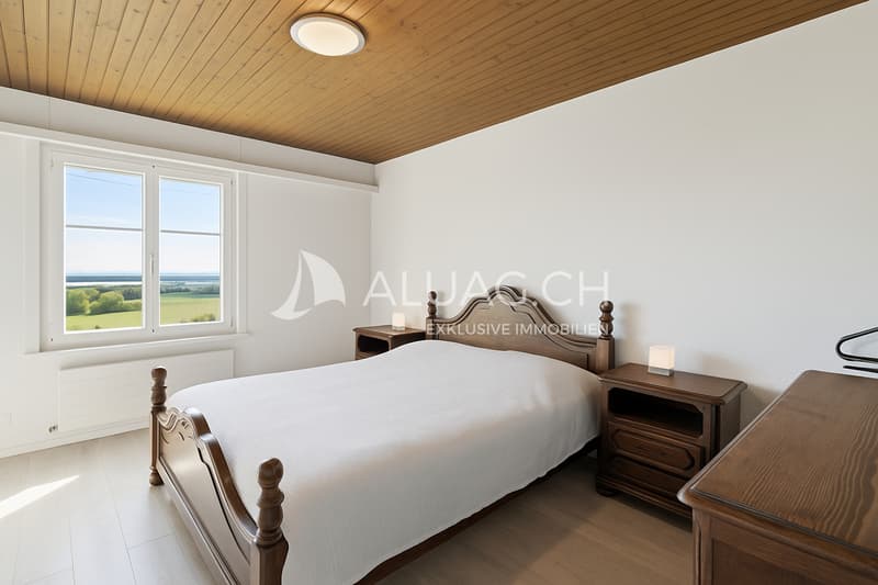 Das Schlafzimmer mit Laminatboden und Holzdecke strahlt einen gemütlichen ländlichen Charme aus
