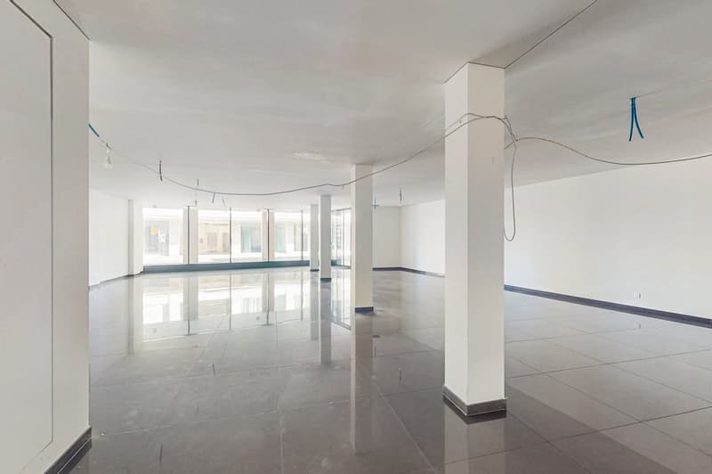 empty space, white walls, gray tile flooring, glass wall