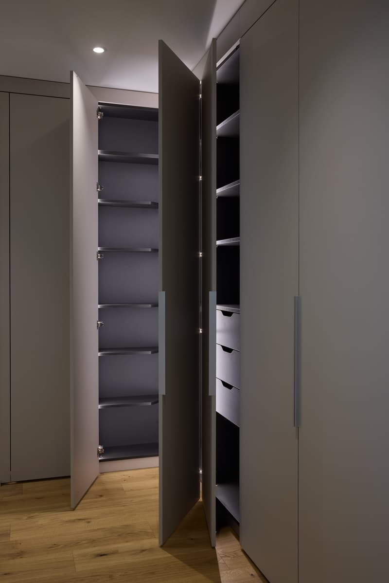 built-in wardrobe, fully open, multiple drawers and shelves, wooden floor, white ceiling