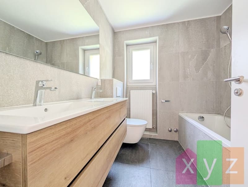 La salle de bain intemporelle équipée d'une baignoire, d'une fenêtre et d'une double vasque
