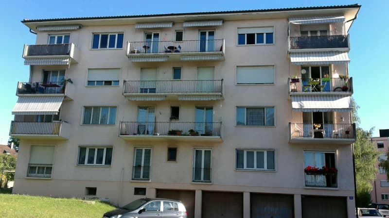 5 story building, balconies, windows, car parked in front