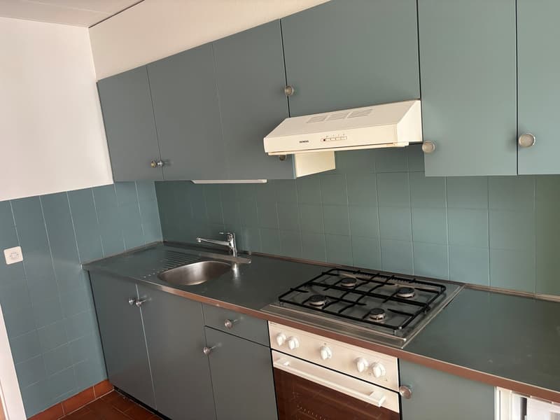 grey cabinet, stainless steel sink, gas stove, oven, power outlet, tiled wall, white tiled floor