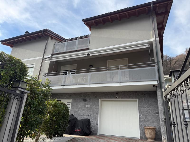 2 story house, gray exterior, white garage, balcony, metal railings, security camera