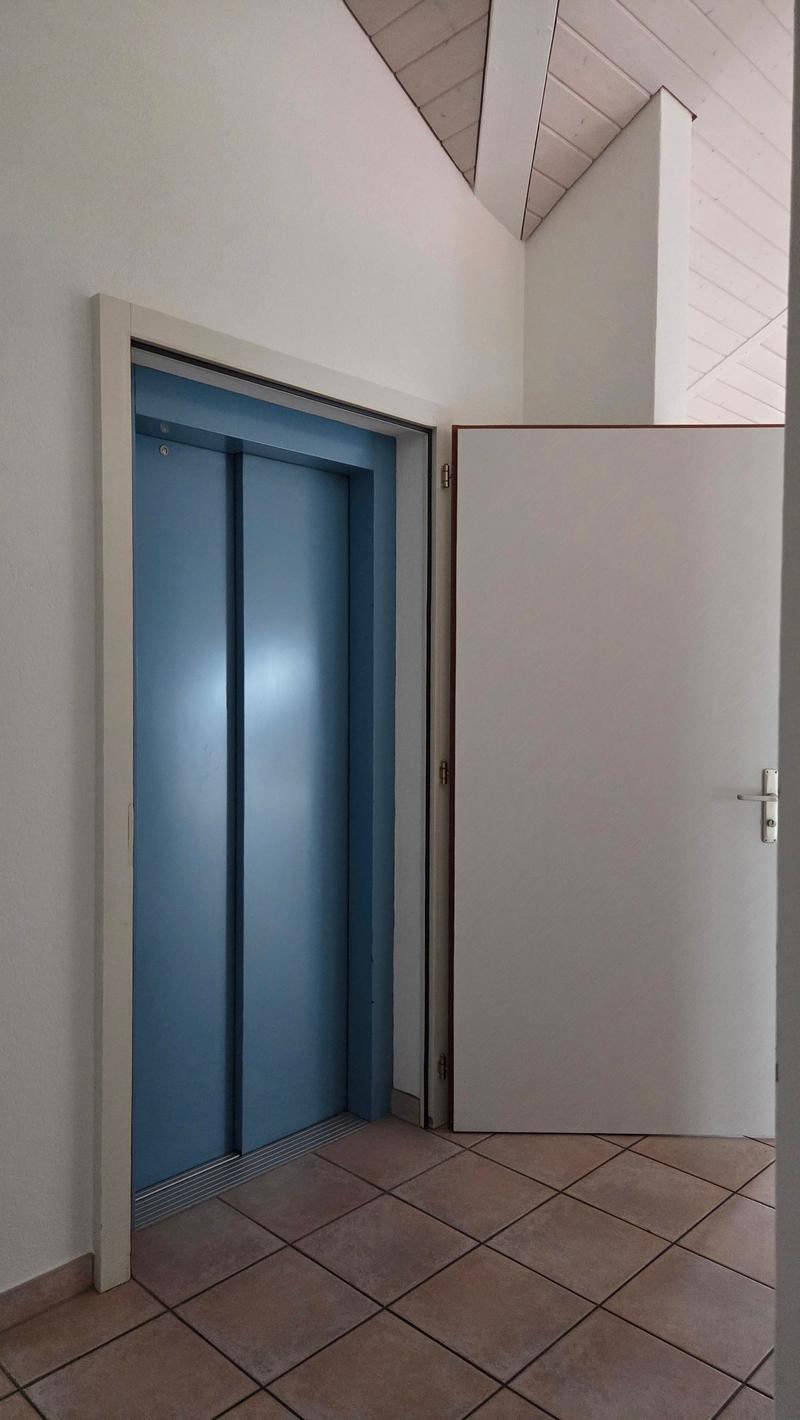 elevator, blue doors, silver trim, closed white door